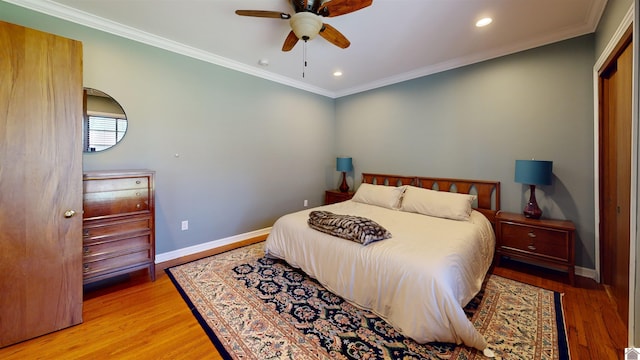 bedroom featuring ceiling fan, crown molding, and light hardwood / wood-style floors