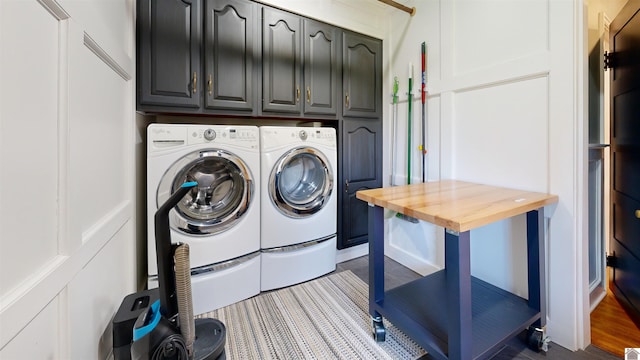 washroom with dark hardwood / wood-style flooring, cabinets, and separate washer and dryer