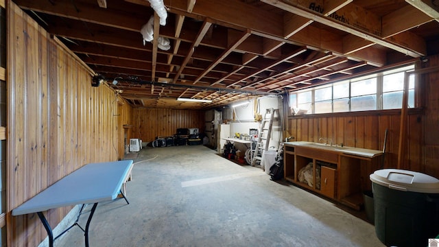 basement with a workshop area and wooden walls