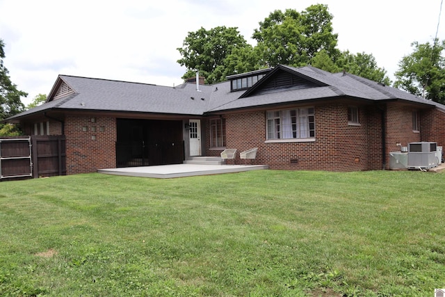 rear view of property featuring a lawn, central AC, and a patio