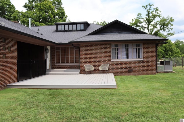 back of property with a lawn, central AC, and a deck