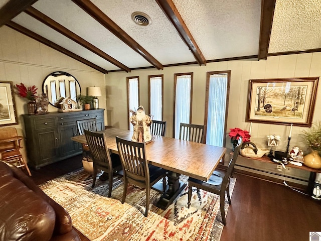 dining space featuring a textured ceiling, lofted ceiling with beams, and hardwood / wood-style flooring