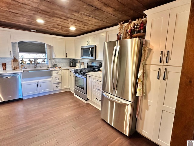 kitchen with white cabinetry, sink, appliances with stainless steel finishes, and light hardwood / wood-style flooring