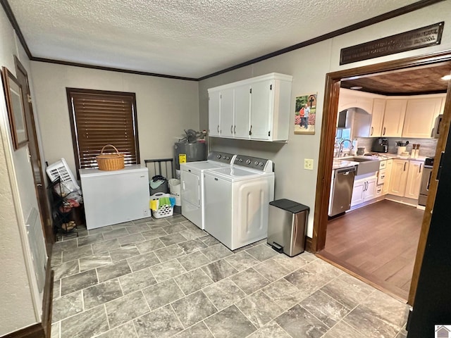 laundry room with cabinets, sink, independent washer and dryer, light wood-type flooring, and ornamental molding