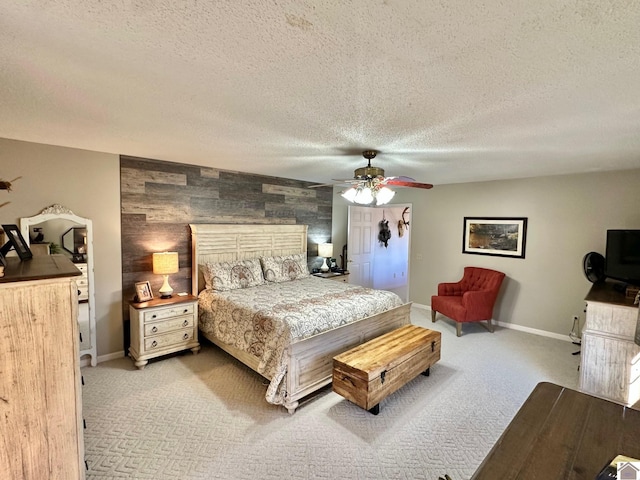 bedroom with a textured ceiling, ceiling fan, and light carpet