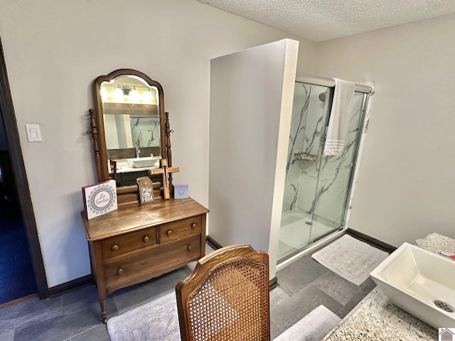 bathroom featuring vanity, a textured ceiling, and a shower with door