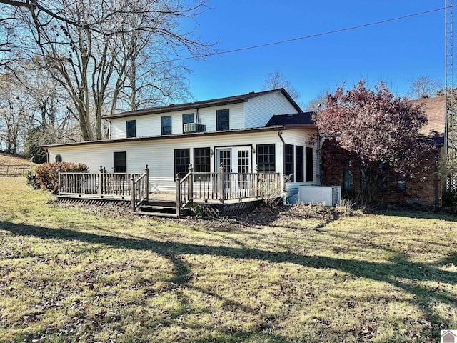 rear view of property featuring a lawn, a wooden deck, and central AC