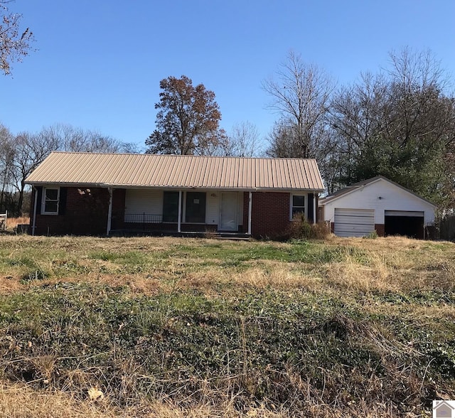 ranch-style home with covered porch, an outbuilding, and a garage