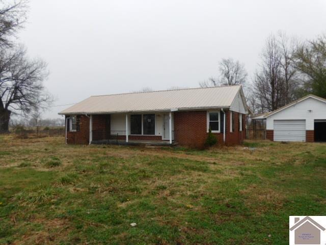 82 Ingleside Rd, Kevil, KY 42053 - ranch-style home featuring a detached garage, brick siding, covered porch, a metal roof, and an outdoor structure