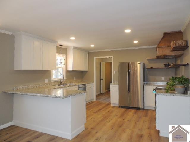 kitchen featuring stainless steel fridge, white cabinetry, sink, and light hardwood / wood-style flooring