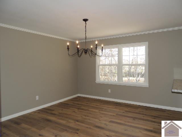 spare room featuring a notable chandelier, dark hardwood / wood-style floors, and crown molding