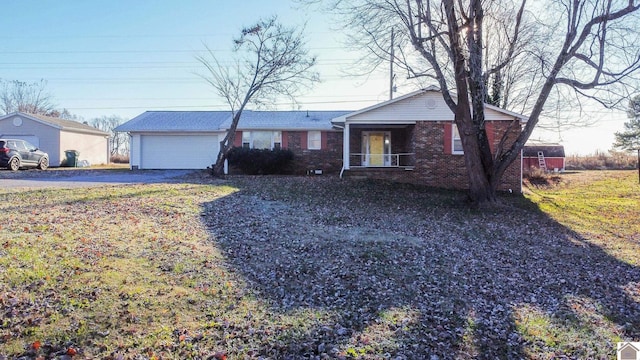 ranch-style house featuring covered porch, a garage, and a front yard