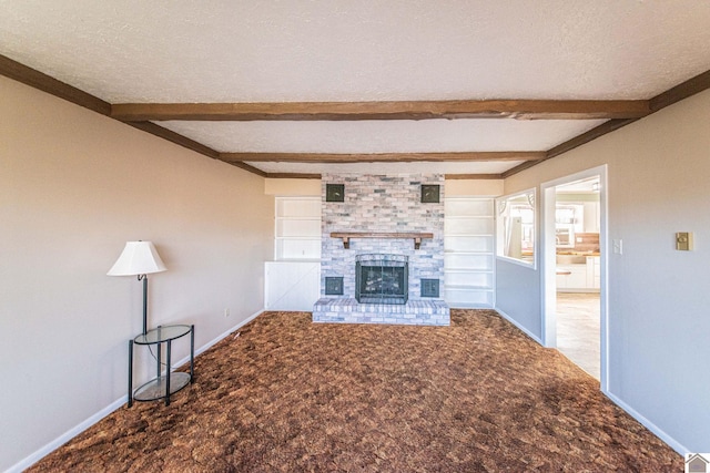 unfurnished living room with a brick fireplace, built in features, a textured ceiling, beam ceiling, and carpet floors