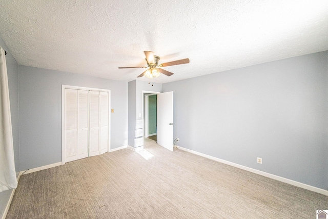 unfurnished bedroom featuring ceiling fan, light wood-type flooring, a textured ceiling, and a closet