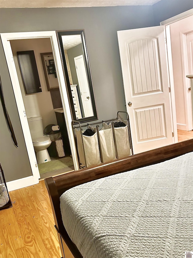 bedroom featuring ensuite bathroom and light hardwood / wood-style flooring