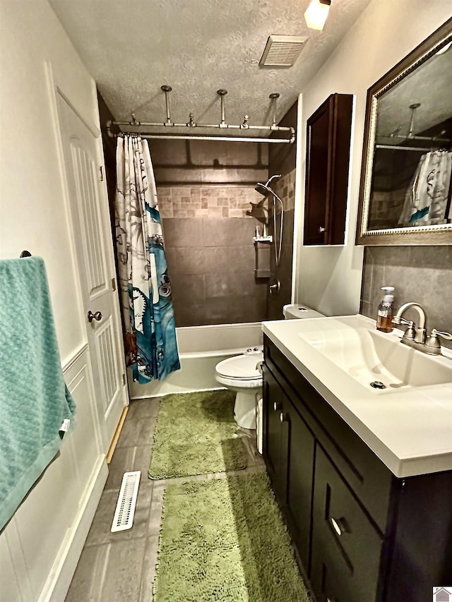 full bathroom with shower / bath combo, vanity, tile patterned floors, toilet, and a textured ceiling