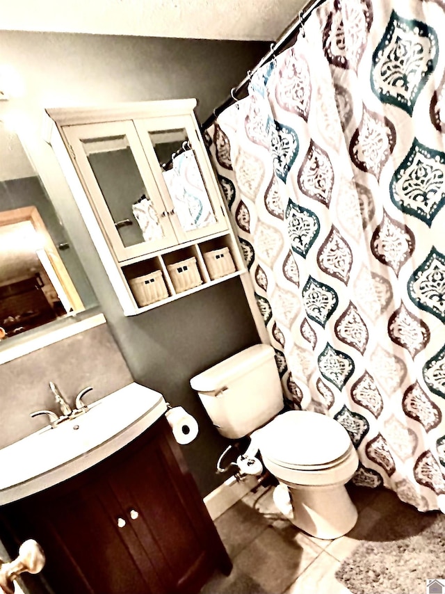 bathroom with tile patterned flooring, vanity, and toilet