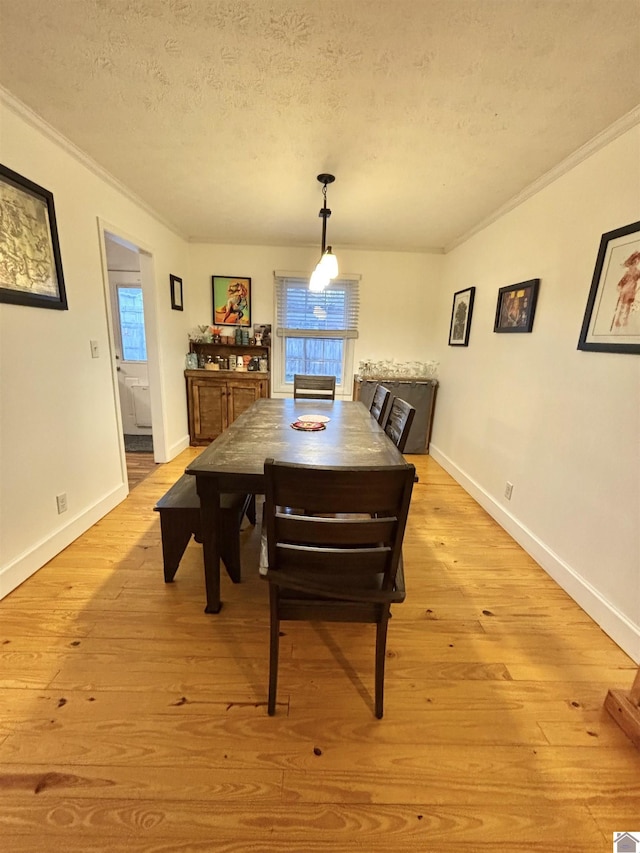 dining space with a healthy amount of sunlight, ornamental molding, a textured ceiling, and light hardwood / wood-style flooring