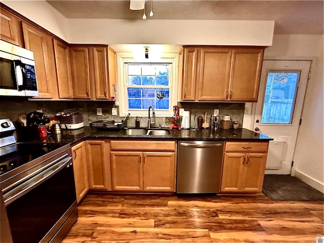 kitchen featuring stainless steel appliances, light hardwood / wood-style flooring, tasteful backsplash, and sink