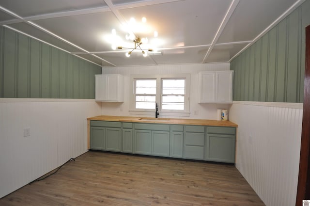 kitchen with butcher block countertops, white cabinetry, sink, and wood-type flooring