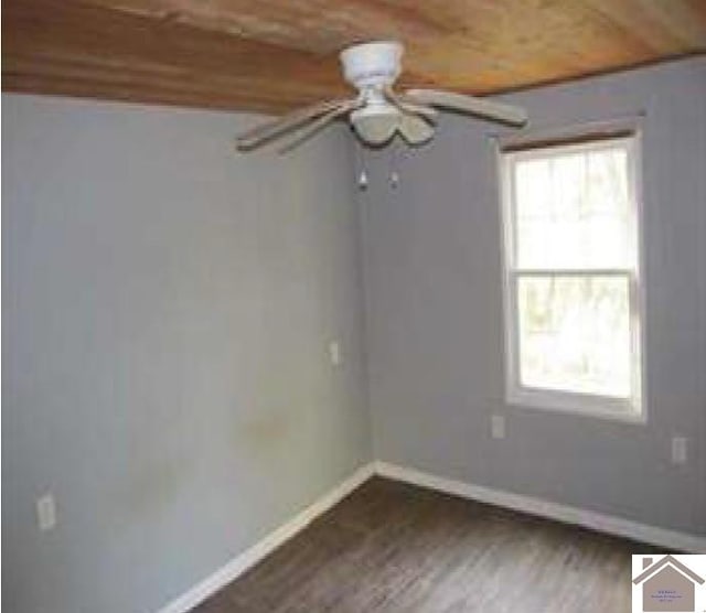 empty room featuring ceiling fan, wooden ceiling, and dark wood-type flooring