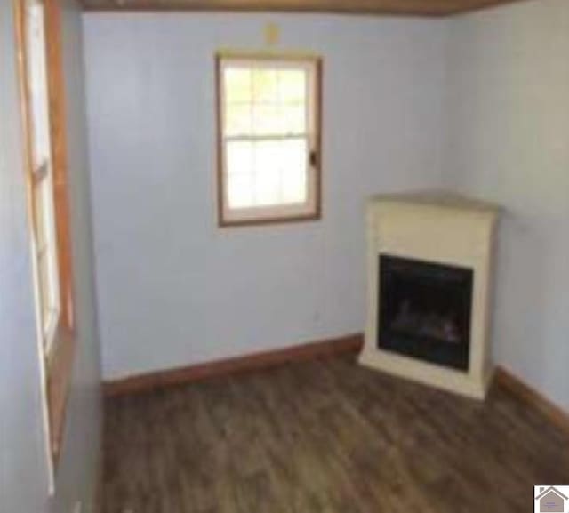 unfurnished living room with dark wood-type flooring