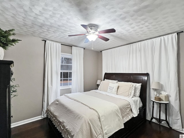 bedroom with a textured ceiling, dark hardwood / wood-style flooring, and ceiling fan