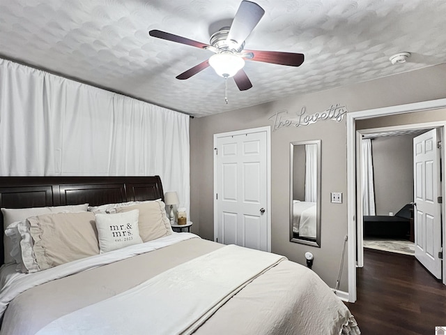 bedroom featuring ceiling fan, dark hardwood / wood-style flooring, and a textured ceiling