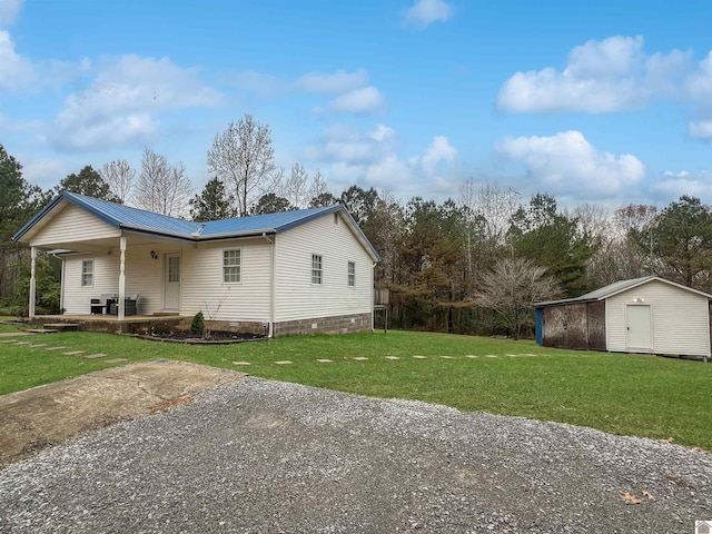 view of home's exterior with a lawn, a storage unit, and a porch