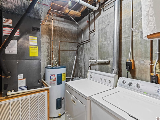 clothes washing area with electric water heater, heating unit, and washer and clothes dryer