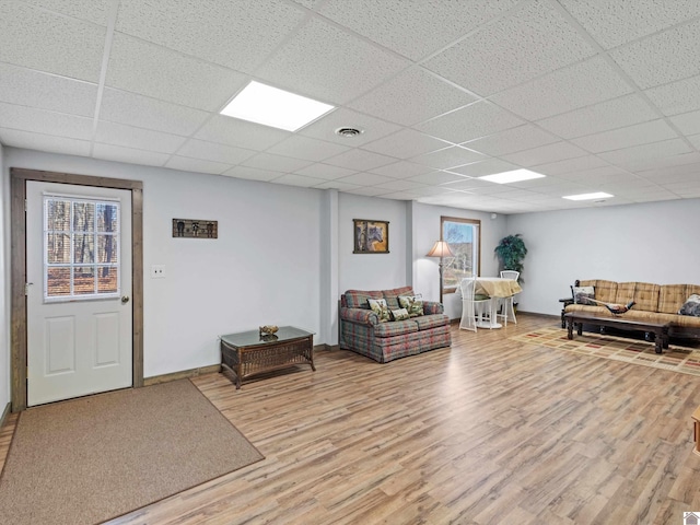 living room with hardwood / wood-style flooring and a drop ceiling