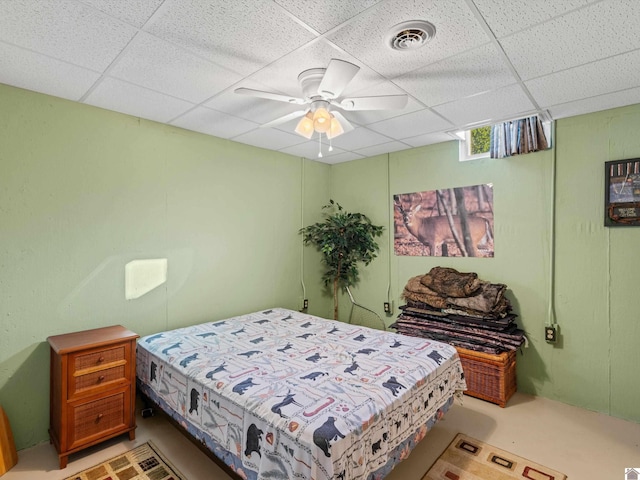 bedroom with ceiling fan and a drop ceiling