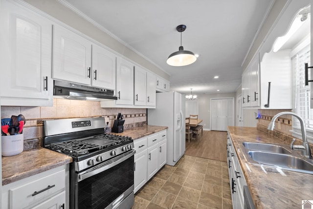 kitchen with stainless steel gas stove, white fridge with ice dispenser, white cabinetry, and sink