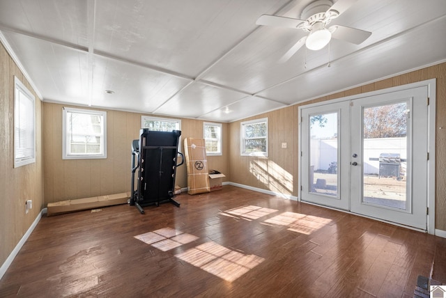 workout area with wooden walls, hardwood / wood-style floors, ceiling fan, and french doors