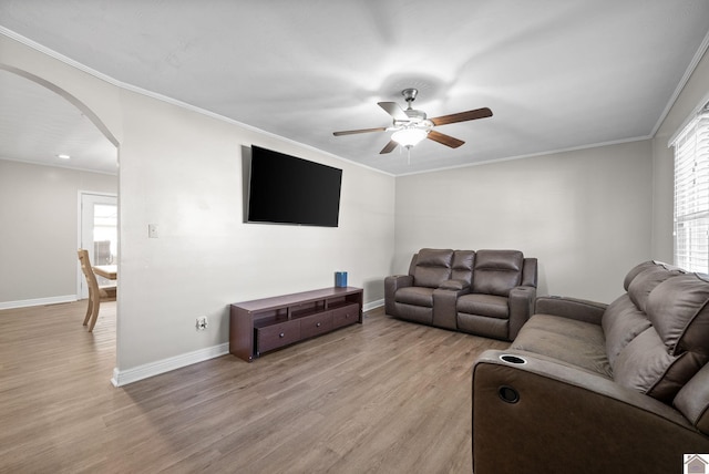 living room with plenty of natural light, ceiling fan, crown molding, and light hardwood / wood-style flooring