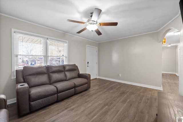 living room with hardwood / wood-style floors, ceiling fan, and crown molding