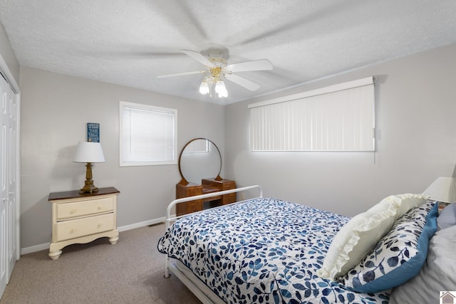 bedroom with carpet, ceiling fan, a textured ceiling, and a closet