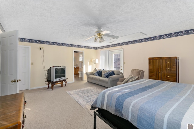 carpeted bedroom with ensuite bath, ceiling fan, and a textured ceiling