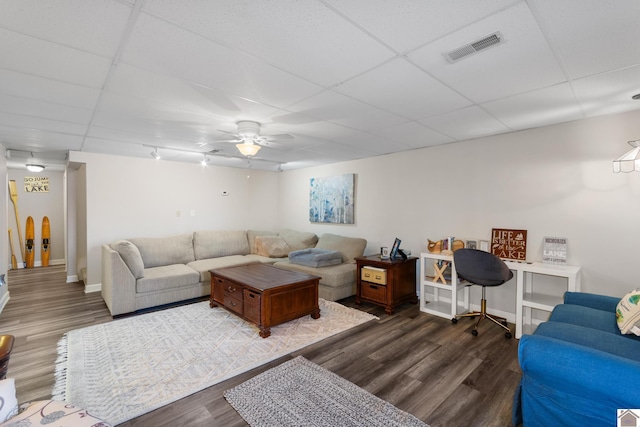 living room with a paneled ceiling, dark hardwood / wood-style floors, and ceiling fan