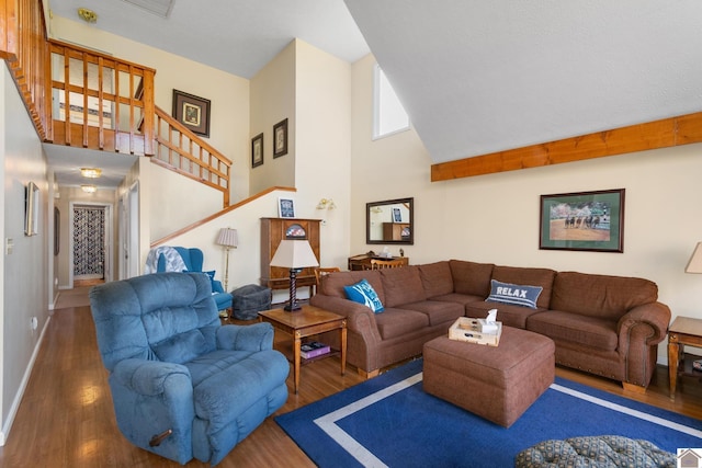 living room with dark wood-type flooring and a high ceiling