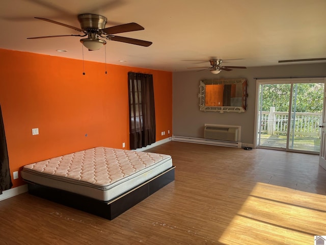 bedroom featuring access to exterior, a wall mounted AC, dark wood-type flooring, and ceiling fan