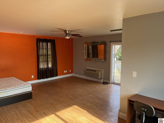 living room featuring hardwood / wood-style flooring, a wall mounted AC, and ceiling fan