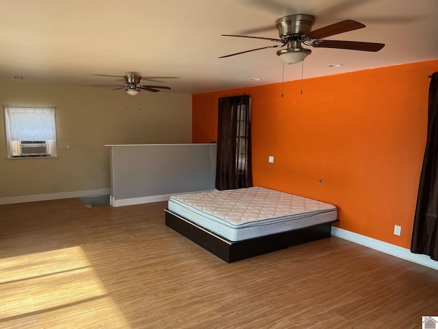 unfurnished bedroom with hardwood / wood-style flooring, ceiling fan, and cooling unit