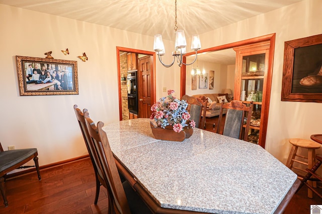 dining area featuring dark hardwood / wood-style floors and a chandelier