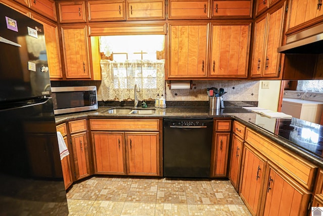 kitchen with sink, washing machine and dryer, exhaust hood, backsplash, and black appliances