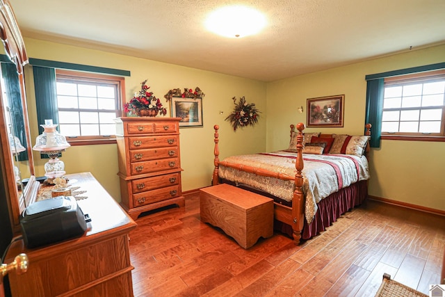 bedroom with hardwood / wood-style floors and a textured ceiling