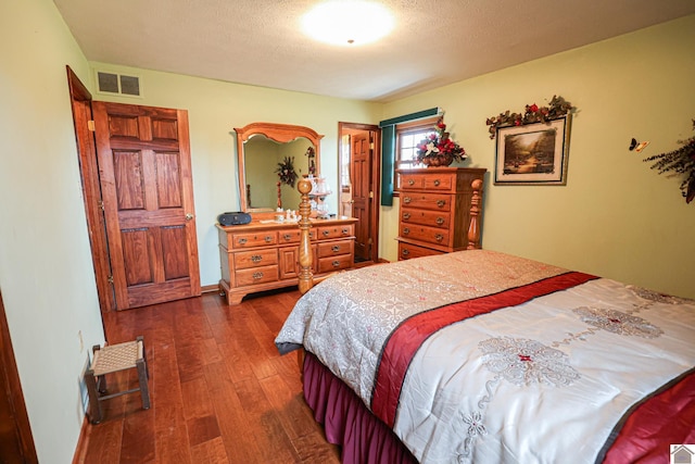 bedroom featuring dark hardwood / wood-style flooring and a textured ceiling