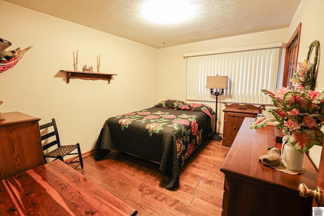 bedroom featuring light hardwood / wood-style floors and a textured ceiling