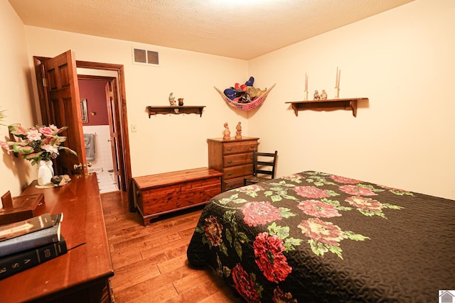 bedroom featuring wood-type flooring and a textured ceiling