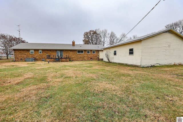 back of property with a yard and central AC unit